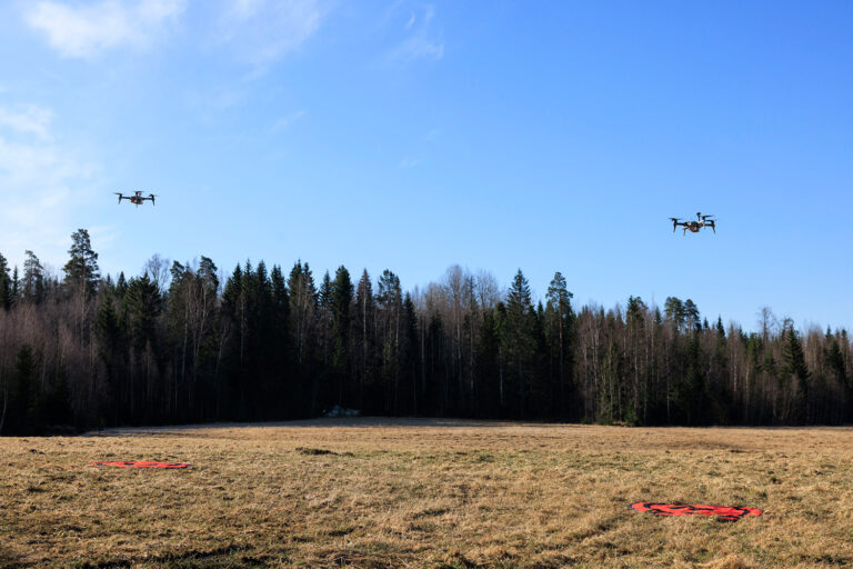Two drones flying over a field
